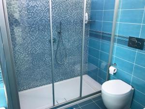 a bathroom with a glass shower with a toilet at Archiammare Sea in San Lorenzo