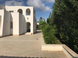 an external view of a white house with trees at Archiammare Sea in San Lorenzo