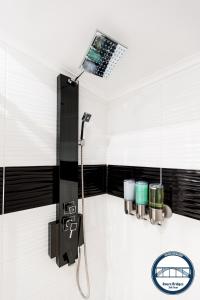 a shower in a bathroom with black and white tiles at Douro Riverside Apartments in Vila Nova de Gaia