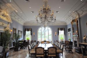 a dining room with a table and chairs and a chandelier at The Inn at Houmas House Estate in Darrow