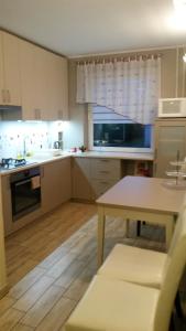 a kitchen with white cabinets and a table and a window at Fishingport in Klaipėda