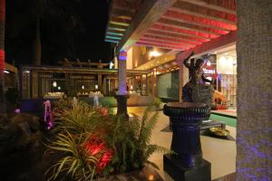 a resort with a statue in a courtyard at night at Hotel Hampi International in Hospet