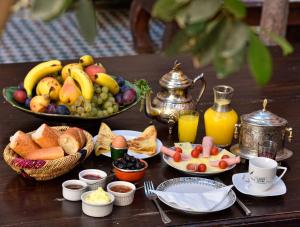 einen Tisch mit einem Haufen Obst und Frühstückslebensmittel in der Unterkunft Riad La Maison Nomade in Marrakesch