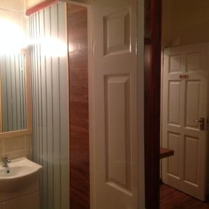 a bathroom with a sink and a white door at Sheehans On Main Street in Kenmare +13 photos