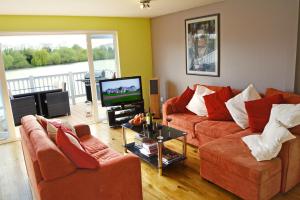 a living room with two couches and a television at Shelduck Lodge in South Cerney