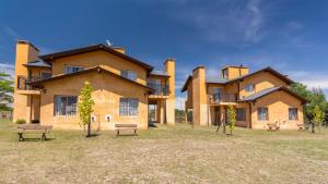 a large building with benches in front of it at Posta Los Reartes in Los Reartes