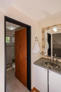 a bathroom with a sink and a toilet and a mirror at Posta Los Reartes in Los Reartes