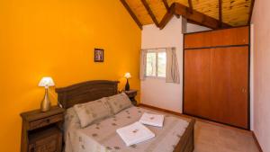 a bedroom with a bed and a wooden door at Posta Los Reartes in Los Reartes +156 photos