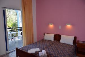 una camera da letto con un letto con due asciugamani sopra di Villa Elia a Limenas Altre 28 foto