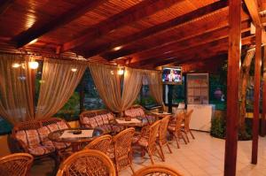 un patio coperto con tavoli, sedie e TV di Villa Elia a Limenas