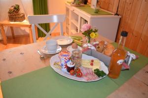 un tavolo con un piatto di cibo e una bottiglia di Bauernhof König a Anger