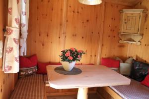 a small room with a table with a vase of flowers at Ferienwohnung Eder in Hippach