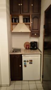 eine kleine Küche mit einem weißen Kühlschrank und Holzschränken in der Unterkunft Mini Apartment Best Rest in Plowdiw + 31 Fotos