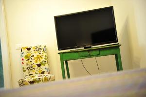 a flat screen tv on a green table with a chair at La Casa del Pescatore in Sarnico