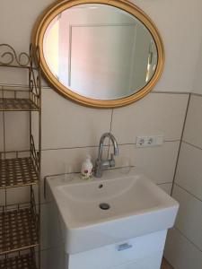 a bathroom with a sink and a mirror at Ferienwohnung & Wellness in Bad Kissingen