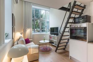 un soggiorno con letto a soppalco e divano di Domus 21 - Entreparedes a Porto