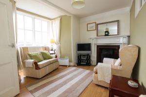 a living room with two chairs and a fireplace at Scenery Cottage in Bridford