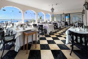
a restaurant with tables, chairs, and tables in it at Hotel Quinta das Vistas in Funchal
