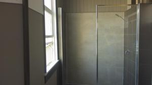 a shower with a glass door and a window at Hotel Kerwick in Redbank