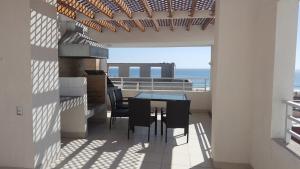 a balcony with a table and chairs and the ocean at Edificio One in Iquique