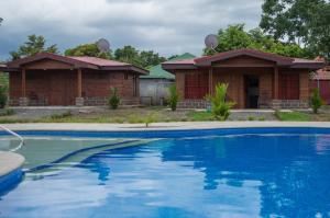 a house with a swimming pool in front of it at Cabañas San Isidro in Ángeles