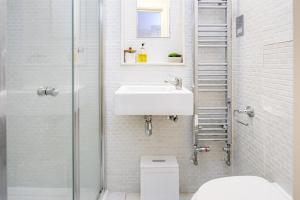 a bathroom with a sink and a toilet and a shower at Square Mile Residences in London