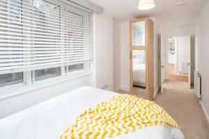 a bedroom with a bed with a yellow and white blanket at Square Mile Residences in London
