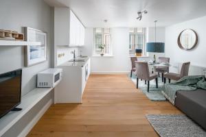 a kitchen and living room with a couch and a table at Square Mile Residences in London