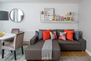 a living room with a couch with colorful pillows at Square Mile Residences in London