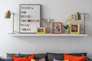 a shelf above a couch with pictures on it at Square Mile Residences in London