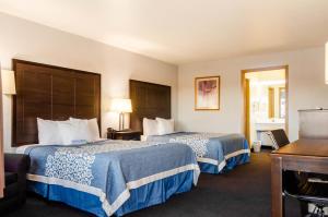 a hotel room with two beds and a desk at Days Inn by Wyndham Panguitch in Panguitch