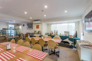 a restaurant with tables and chairs in a room at Arena Hotel (formerly Sleep Express Motel) in Sydney