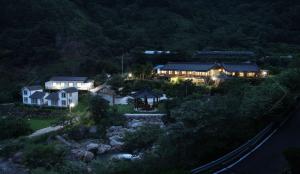 una casa grande con luces por la noche en Buchungol Pension en Hadong