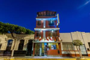 un bâtiment avec une tour d'horloge devant lui dans l'établissement Hostal Iquique, à Lima