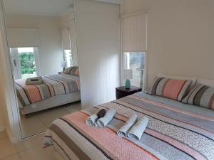 A bed or beds in a room at MODERN 3 BEDROOM APARTMENT IN TRADITIONAL QUEENSLANDER , PATIO, LEAFY YARD, POOL