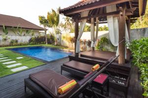 a backyard with a pool and a gazebo at Puri Saron Hotel Baruna Beach Lovina in Lovina