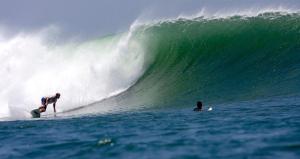 un hombre montando una ola en una tabla de surf en el océano en Sirena Surf Lodge Miramar Nicaragua en Miramar