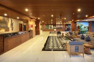 a lobby with couches and a bar in a building at ASTON Canggu Beach Resort in Canggu