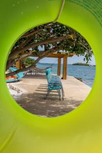 a green chair sitting on the beach near the water at Serene by the Sea in Savaneta