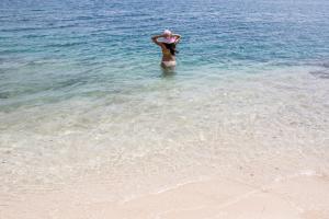 a woman standing in the water at the beach at Serene by the Sea in Savaneta