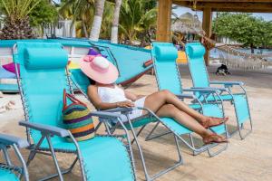 a woman sitting in a chair at the beach at Serene by the Sea in Savaneta