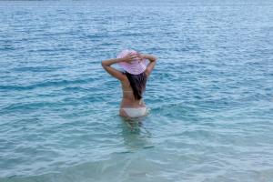 a woman in the water with a hat on her head at Serene by the Sea in Savaneta