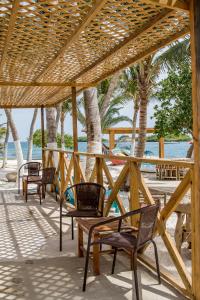 a group of chairs sitting under a pavilion on the beach at Serene by the Sea in Savaneta