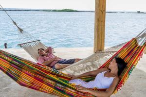 two people laying in a hammock by the water at Serene by the Sea in Savaneta