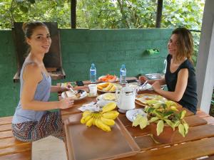 two women sitting at a table eating food at Airport Green Hotel in Katunayake