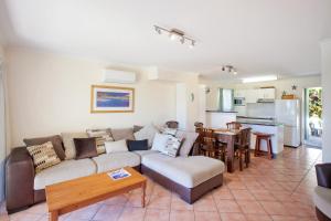 een woonkamer met een bank en een tafel bij Beach Breakers Resort in Sunrise Beach