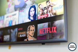 a television screen with movies on a wall at Douro Riverside Apartments in Vila Nova de Gaia