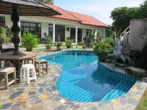 a swimming pool in front of a house at Tree Roots Retreat in Rayong
