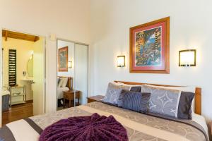 a bedroom with a large bed with a purple rug on it at Abri Apartments in Paihia