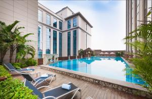 a large swimming pool with chairs and a building at Marco Polo Jin Jiang in Jinjiang